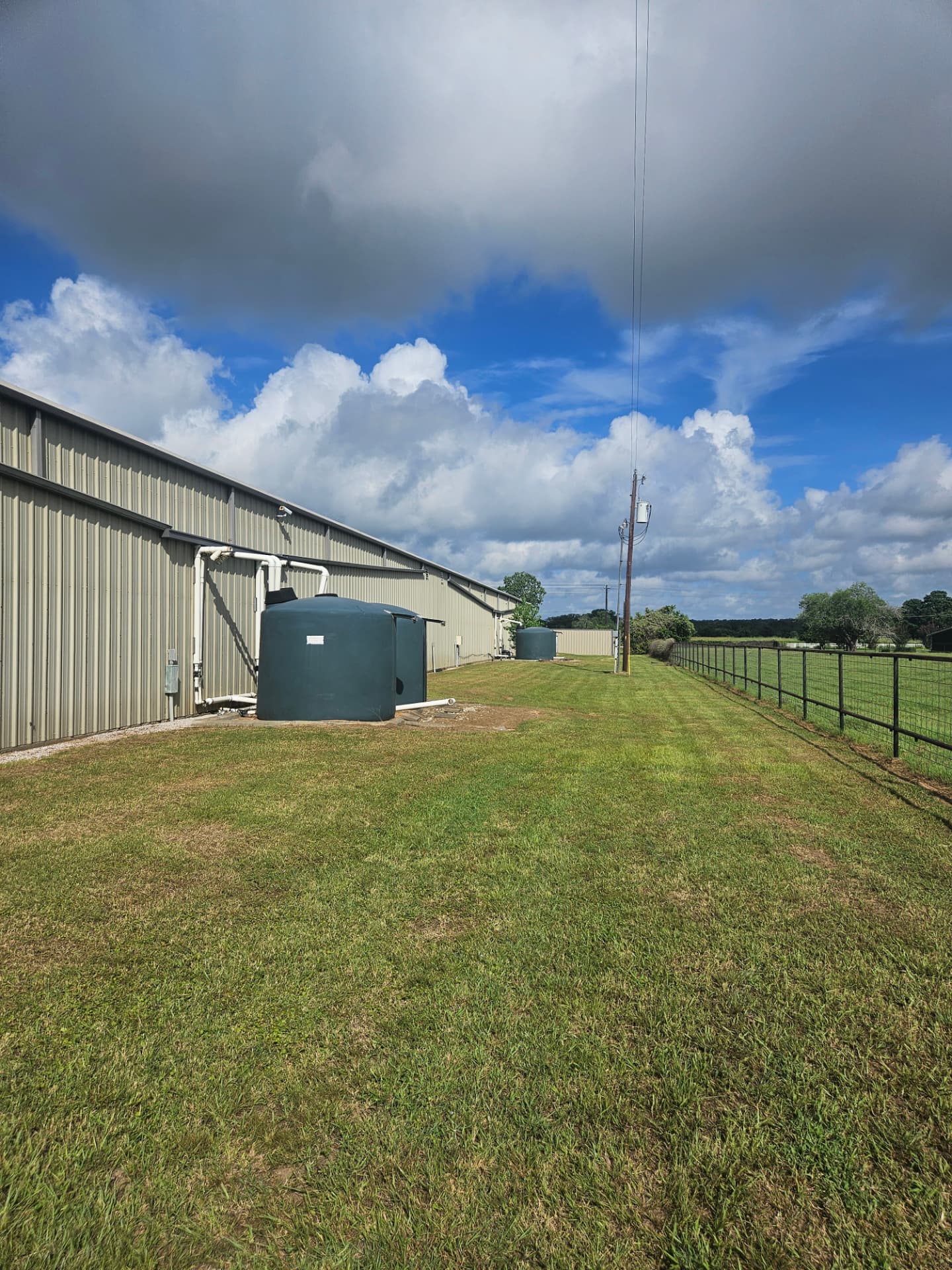 Rainwater harvesting storage tanks and collection infrastructure installed alongside a building.