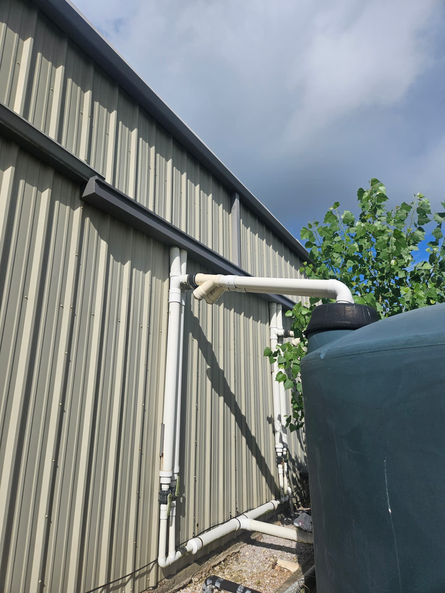 Rainwater harvesting piping and storage tank demonstrating applied water infrastructure.